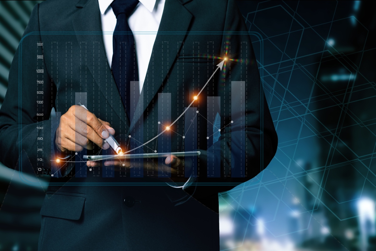 Double exposure of businessman working on digital tablet